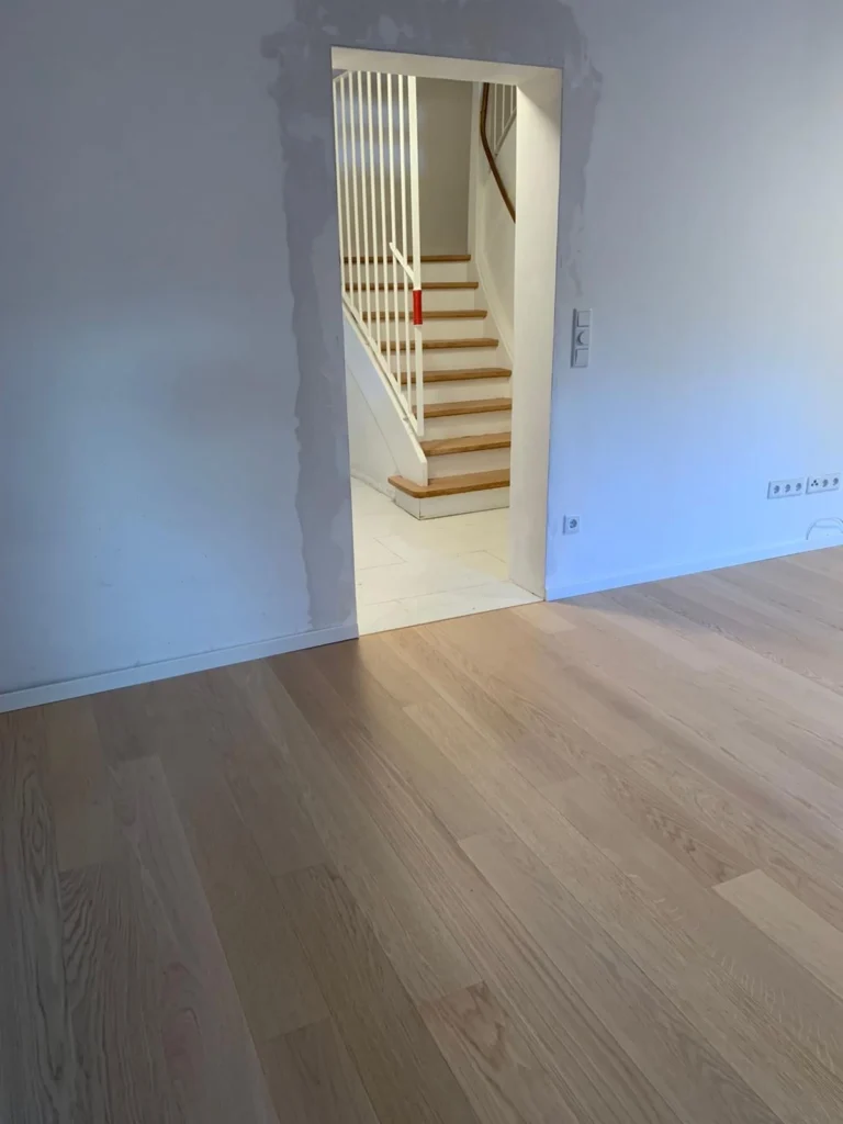 Frisch renovierter Wohnraum mit Treppe und hellem Boden