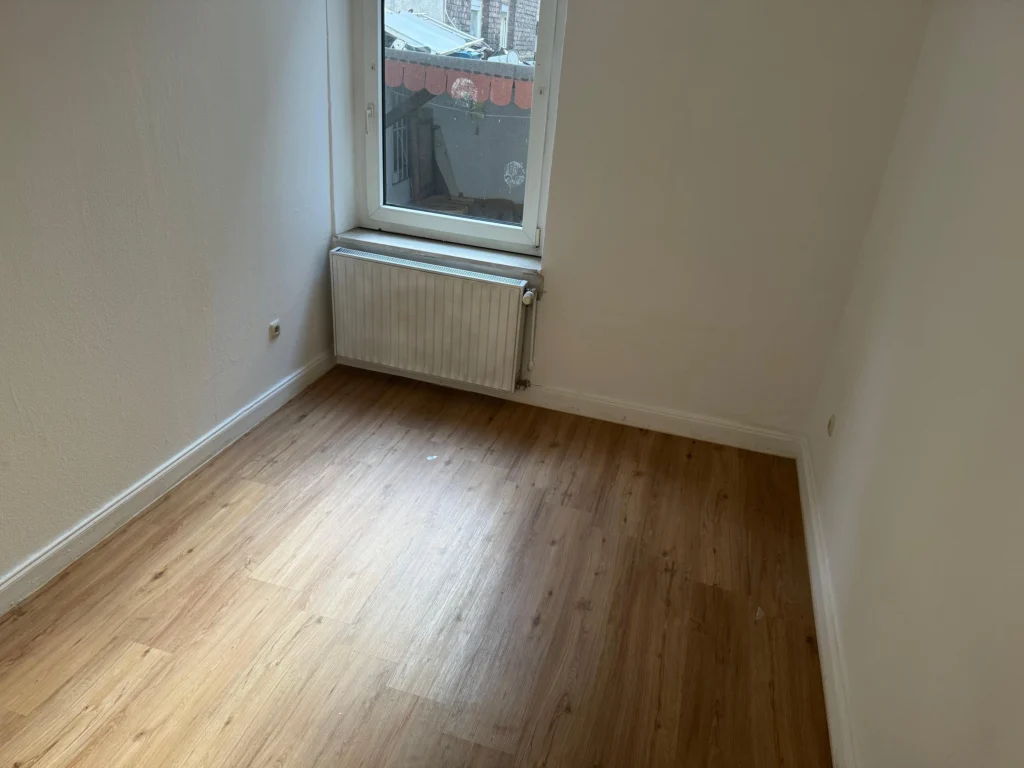 Kleines Zimmer mit neuem Laminatboden und frisch gestrichenen Wänden