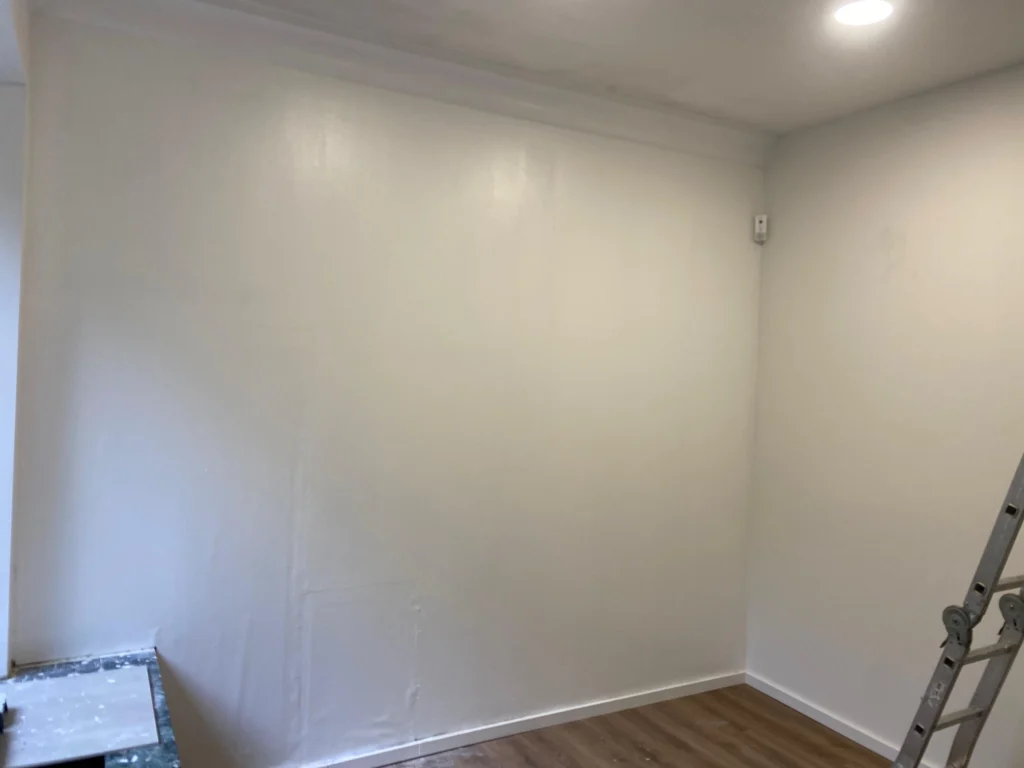 Frisch gestrichene weiße Wand, Leiter im Raum