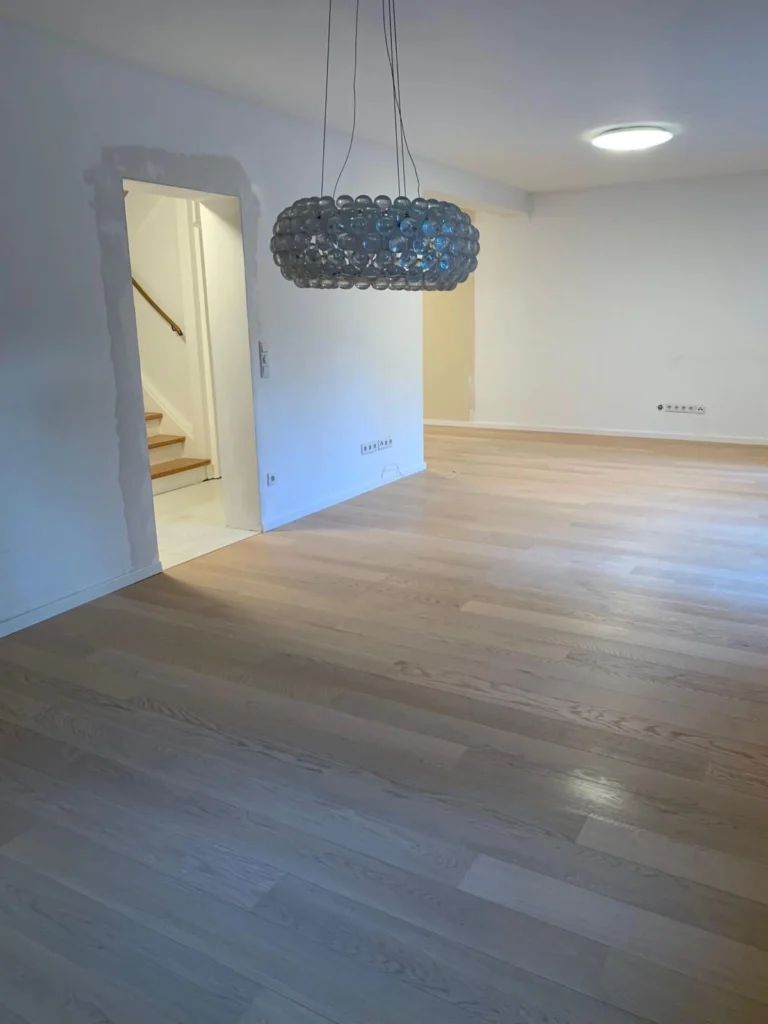 Heller, leerer Wohnraum mit Holzboden nach der Renovierung