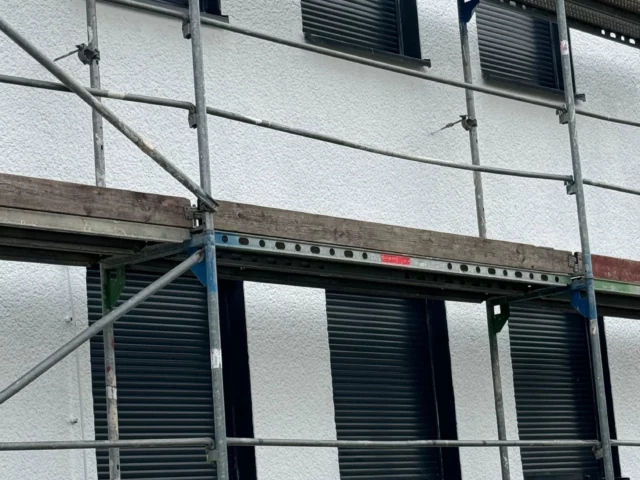 Eingerüstete Hausfassade mit Rollläden
