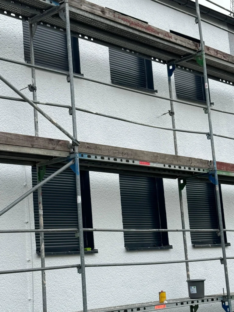 Eingerüstete Hausfassade mit Rollläden