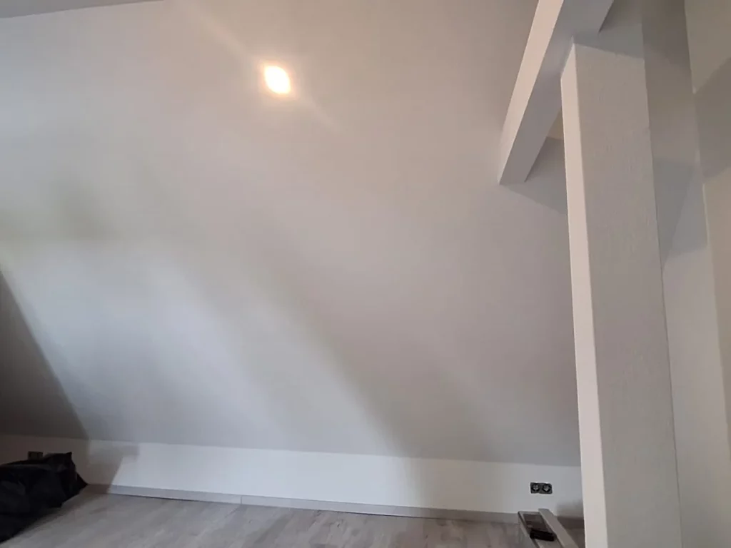 Dachgeschosszimmer mit hellen Wänden, neuem Boden und Sockelleisten
