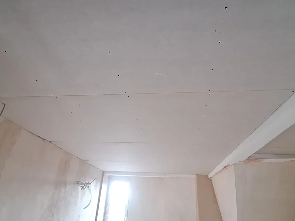 Neu beplankte Gipskartondecke unter einer Dachschräge, Fugen und Schrauben noch sichtbar