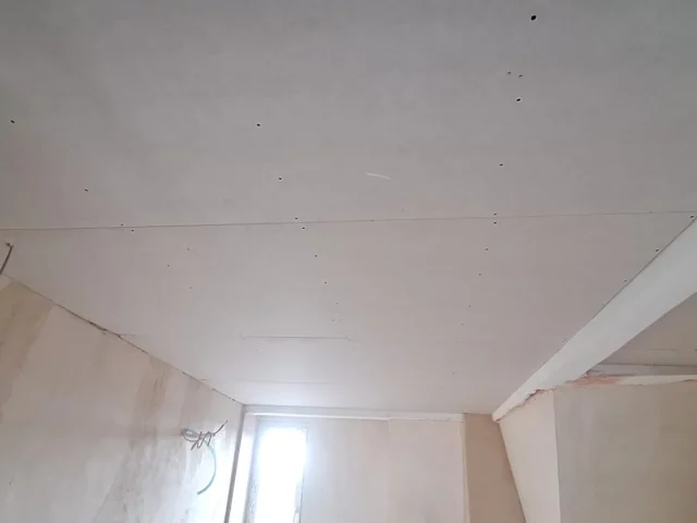 Neu beplankte Gipskartondecke unter einer Dachschräge, Fugen und Schrauben noch sichtbar