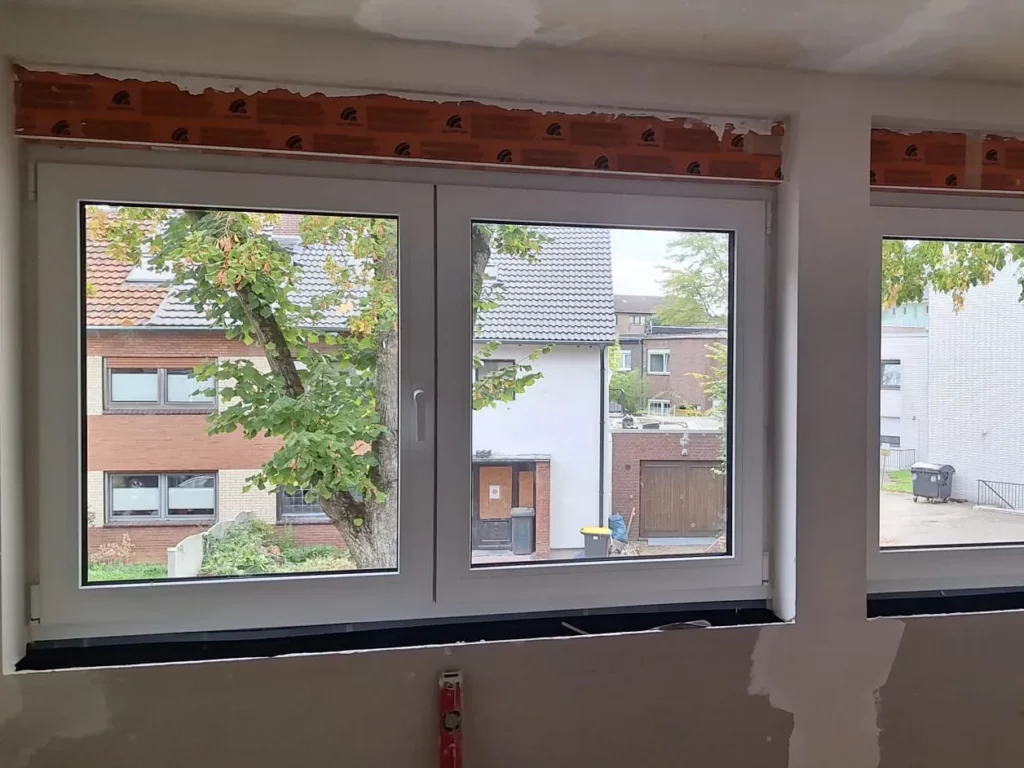 Neu eingebaute weiße Kunststofffenster mit Fensterbank, Laibung noch unverputzt