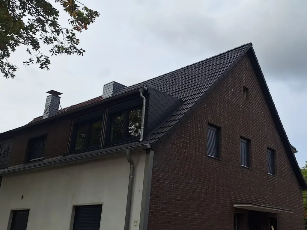 Wohnhaus mit dunkel eingedecktem Steildach und Dachgaube