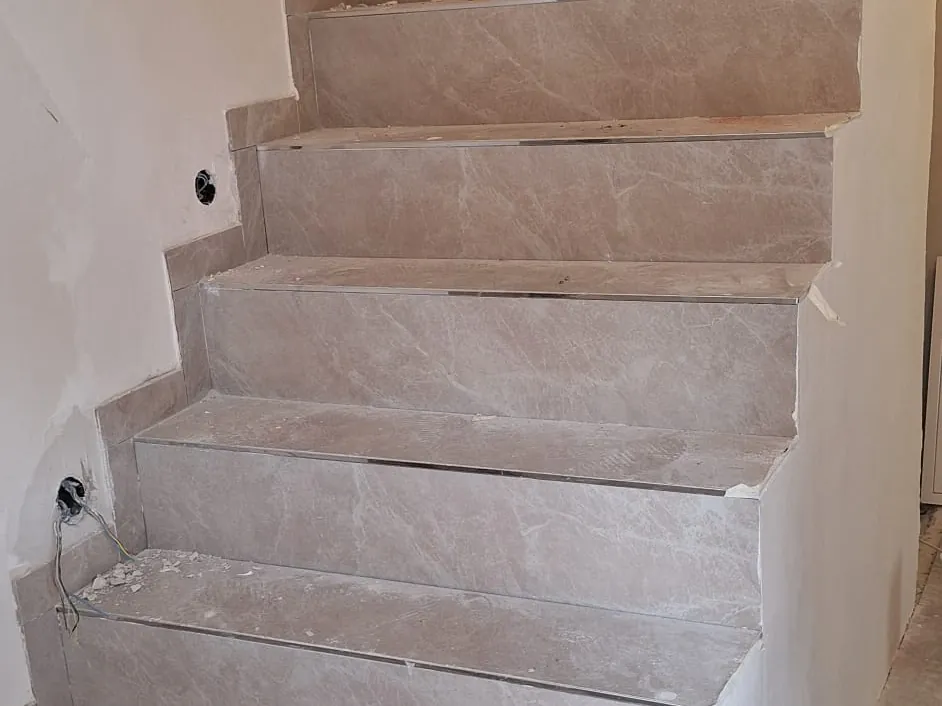 Seitlicher Blick auf eine Treppe, Tritt- und Setzstufen mit großformatigen Fliesen belegt